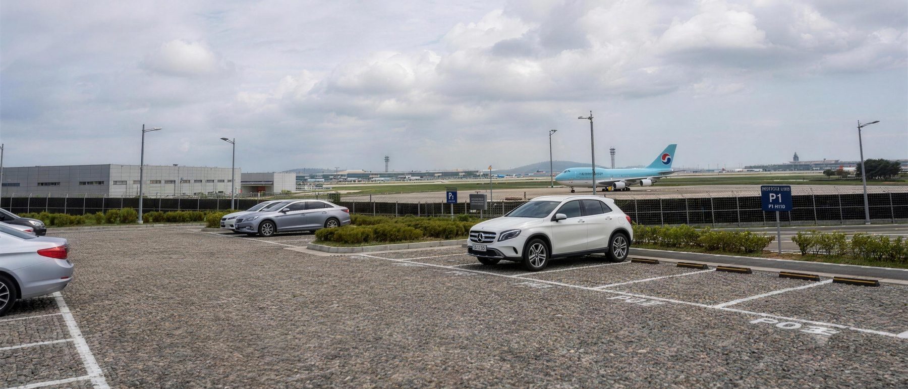 인천공항 활주로 옆 포시즌 주차대행 전용 주차장 전경 — 유도로의 항공기와 주차 차량